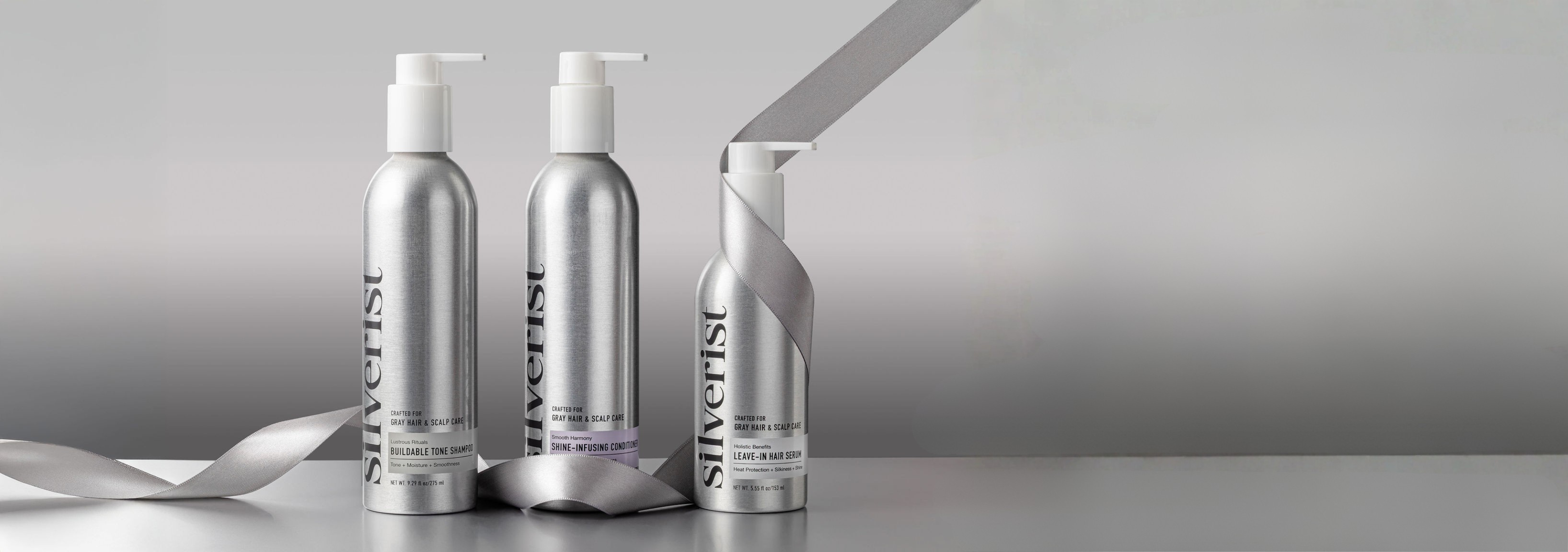 Three bottles of Silverline hair care products on a gray background