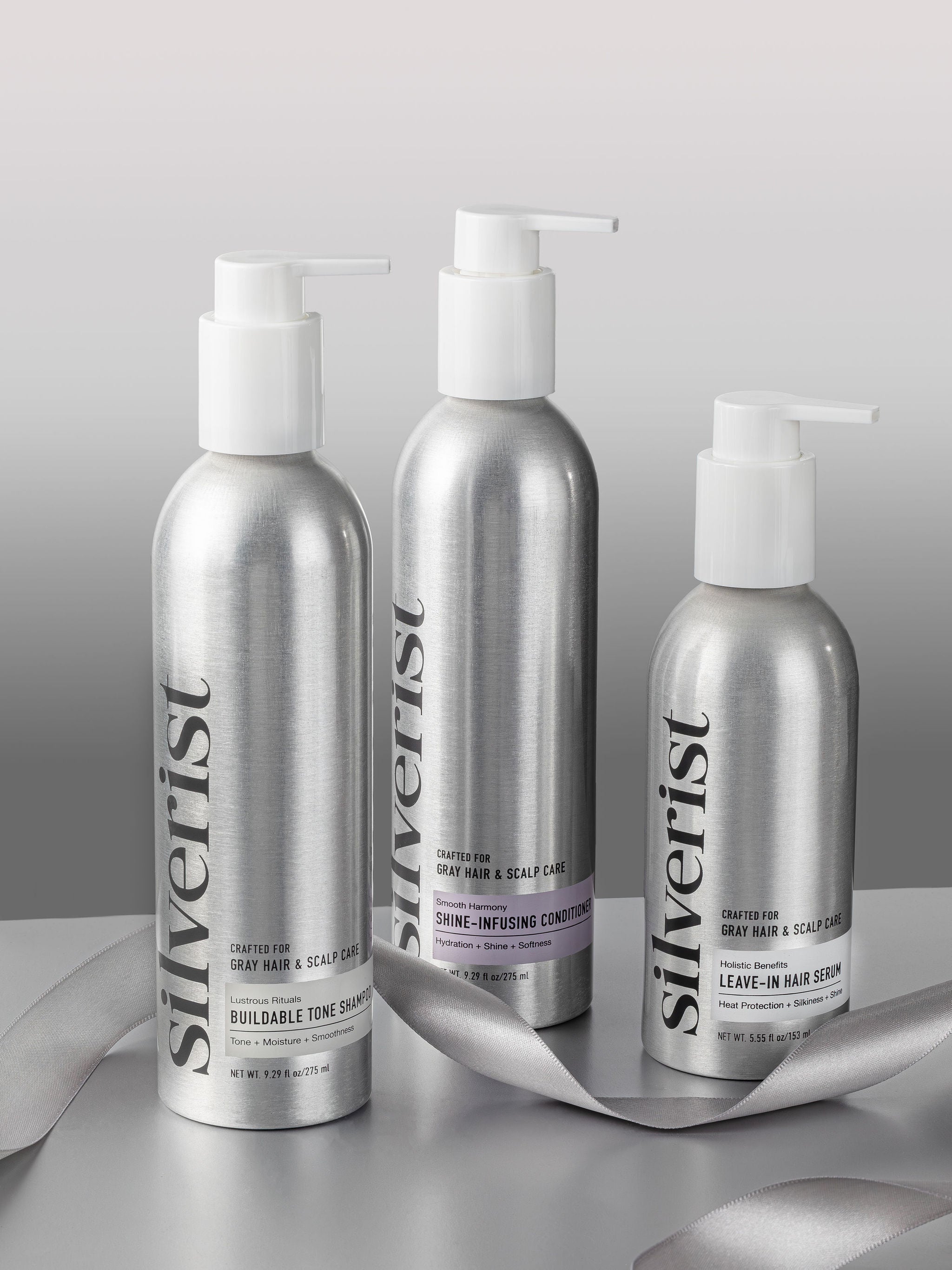 Three bottles of Silverist hair care products on a reflective surface with a gray background