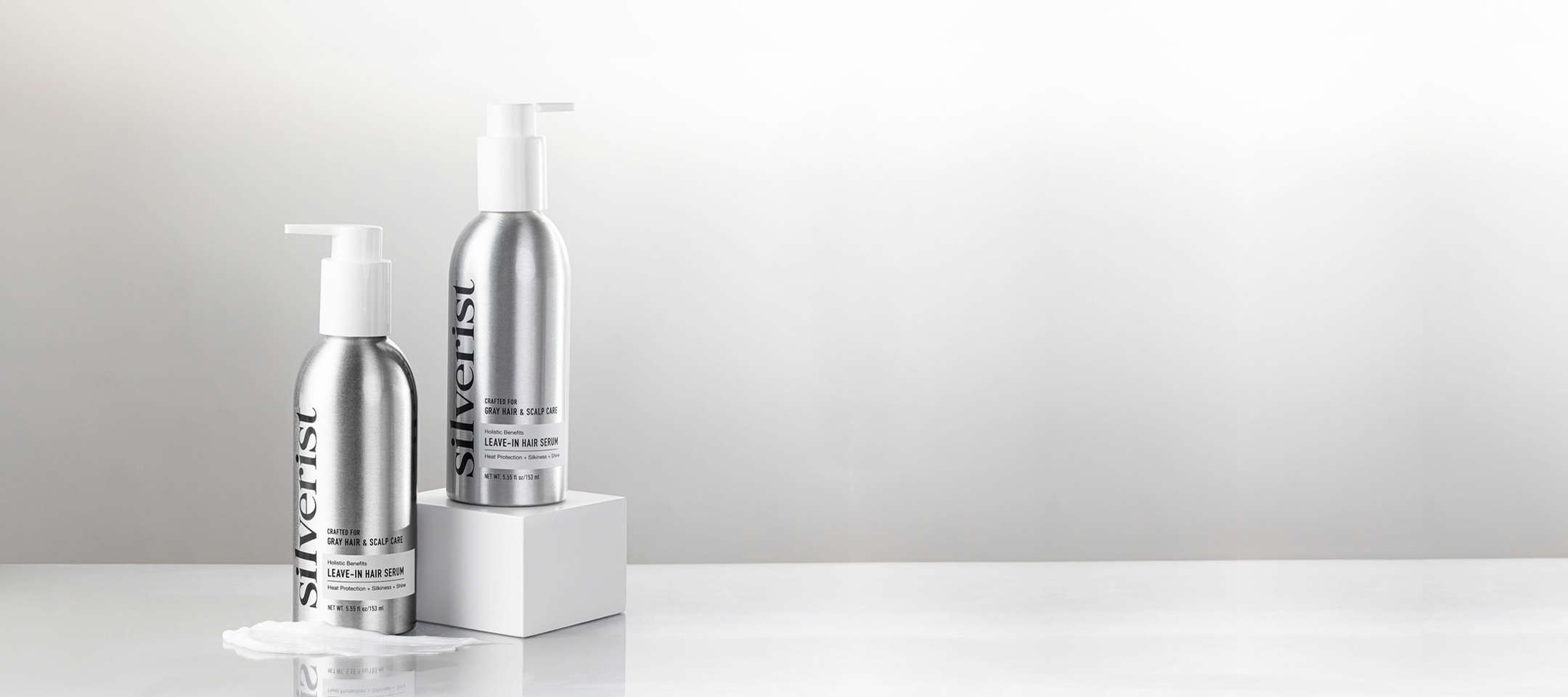 Two metallic silver bottles of Silverist Holistic Benefits Leave-In Hair Serum against a clean light gray background.