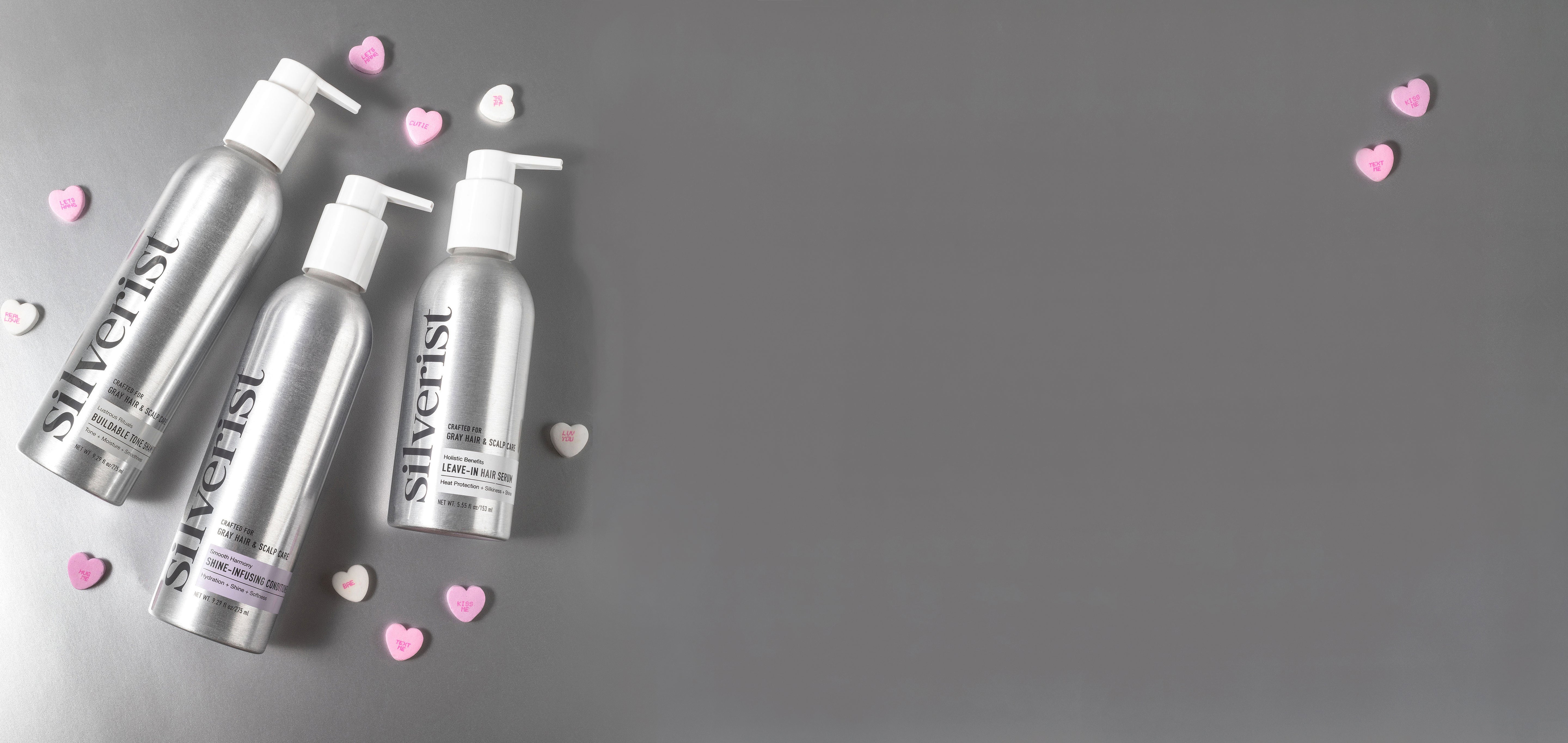 Silverist haircare bottles with pump dispenser on a gray background with pink heart shapes