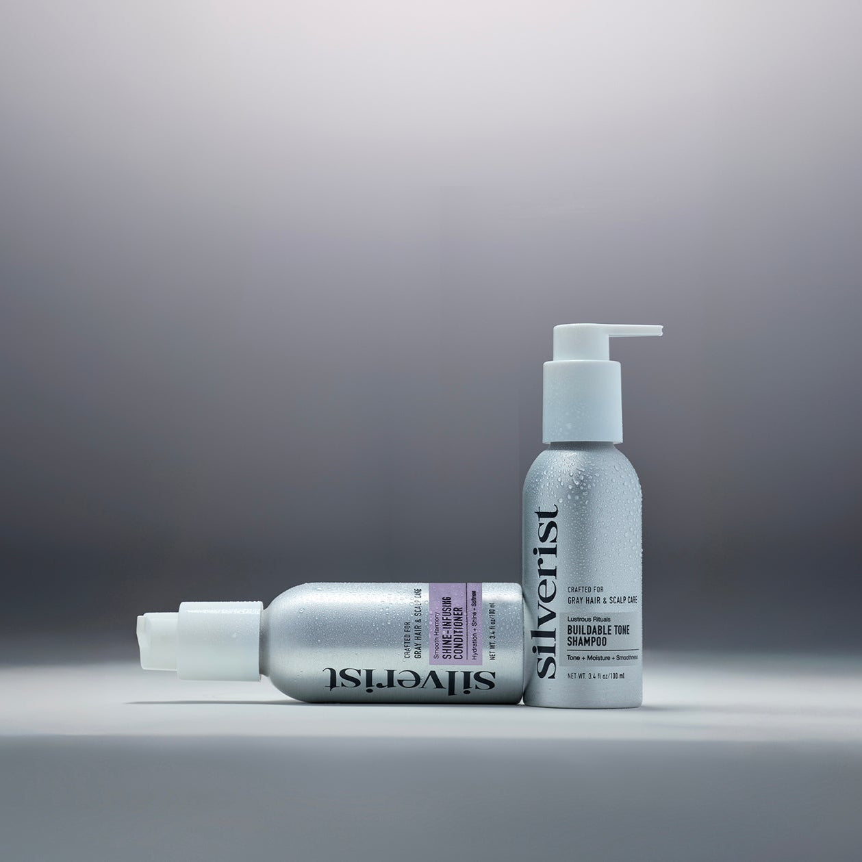 Travel size Silverist shampoo and conditioner bottles on a background with a gradation