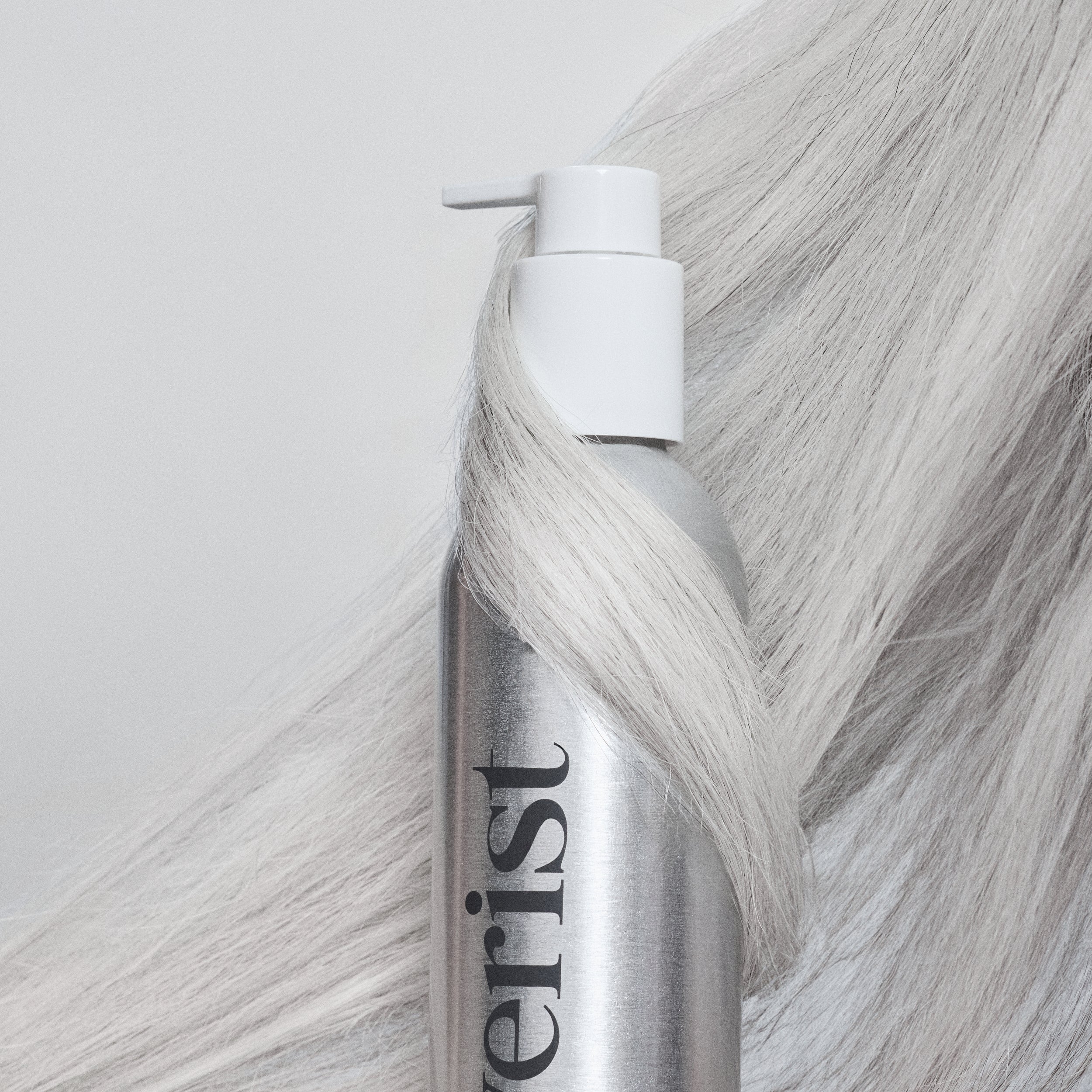 Silverist hair product can with gray hair strands on a light background