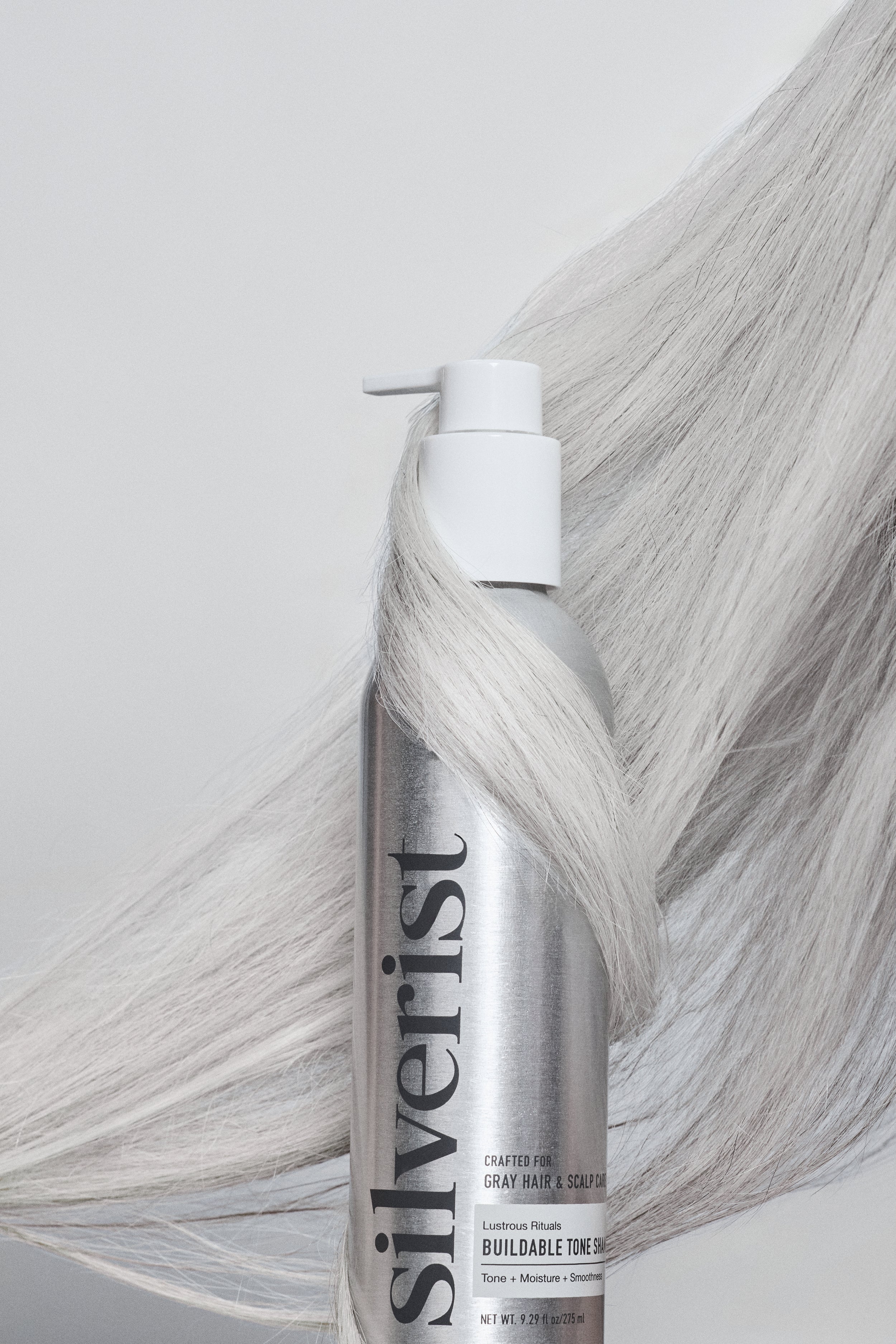 Silverist hair product can with gray hair strands on a light background